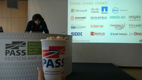 Davide Mauri presenting at SQLKonferenz 2015 while Cathrine is holding a bucket of popcorn.