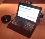 Laptop and jabra speaker phone on a table.