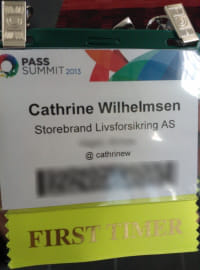 Laminated name badge with a fabric ribbon attached to the bottom.