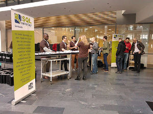 SQLSaturday #275 check-in table with a group of attendees waiting in line.