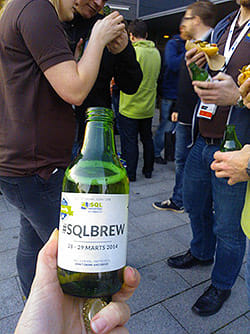 Holding a bottle of beer labeled SQLBrew.