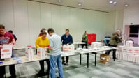 Helpers packing bags on a large table.