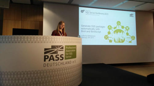 Cathrine standing behind a podium presenting a session at SQLKonferenz 2015.