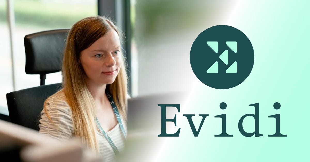 Cathrine Wilhelmsen sitting at her desk wearing an Evidi lanyard.